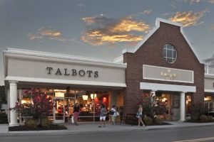 The outside of a Talbots buidling at sunset with people outside