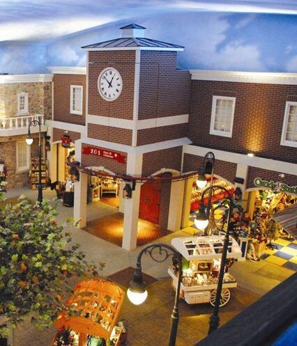 Indoor shop that looks like it's ouside with a fountain, trees, and wagons selling goods