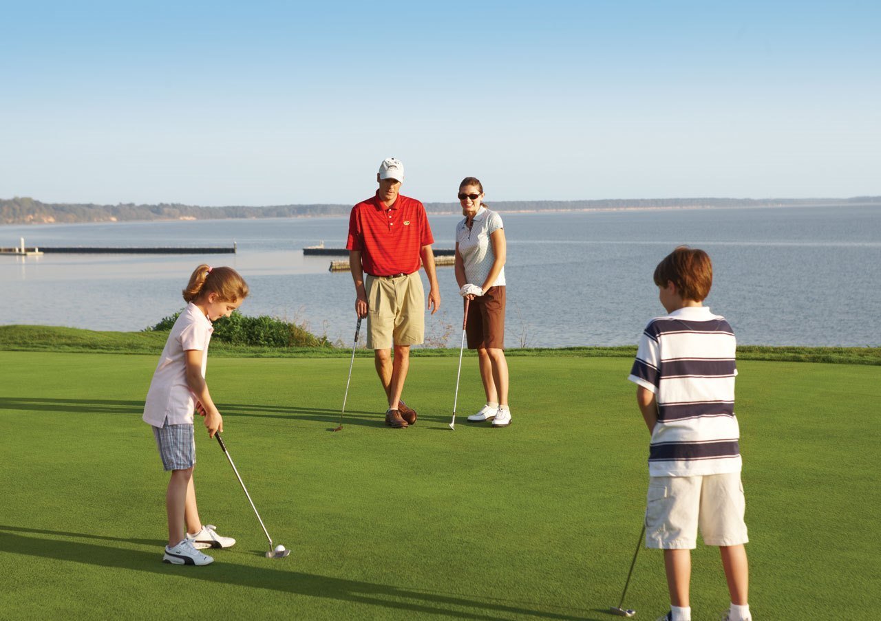 A family of four playing golf