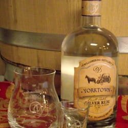 A bottle of Yorktown Silver Rum with a glass and shot glass