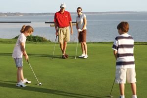 A family of four playing golf